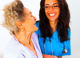 caregiver wearing eyeglasses and senior woman smiling
