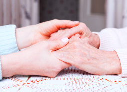 adult woman and senior woman holding hand