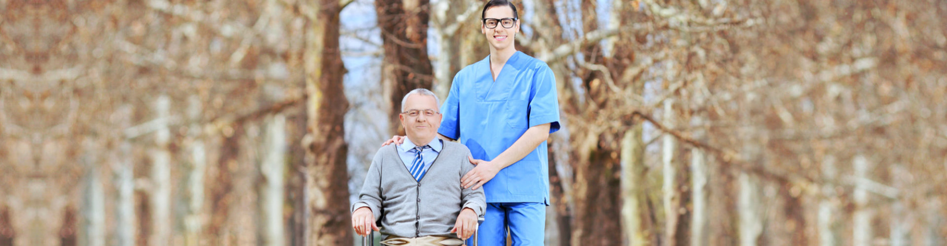 caregiver and senior man sitting on the wheelchair smiling